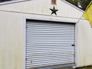 Southern Maine Power and Pressure Washing. Garage before cleaning, with star and yellow flag.